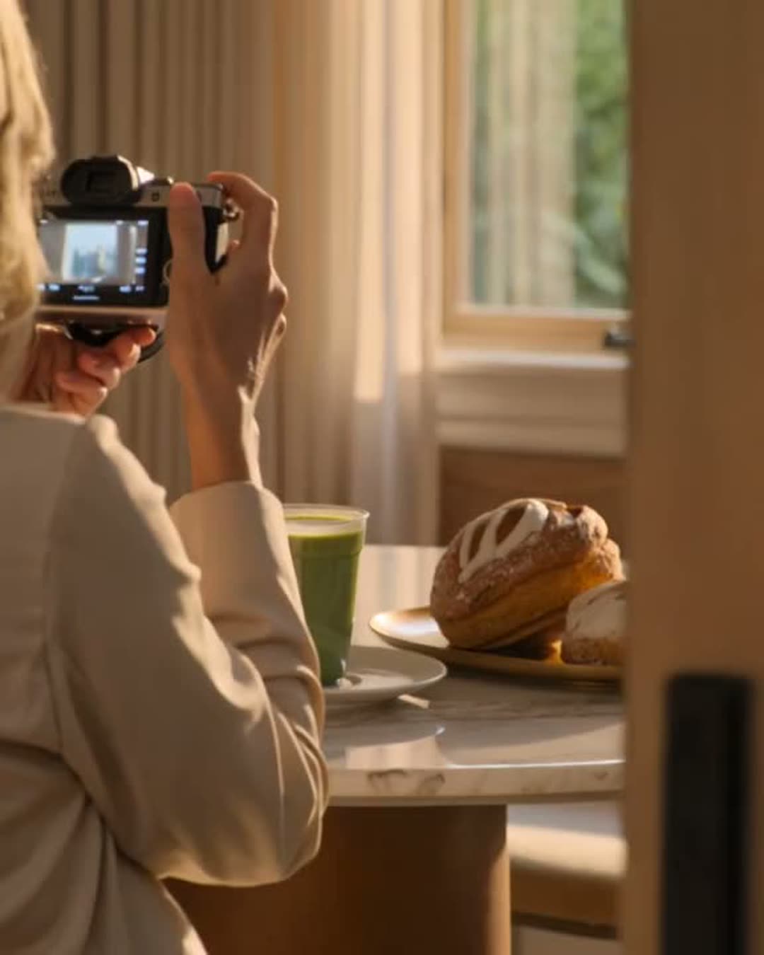 Styled matcha and pastry being photographed on a cafe content day
